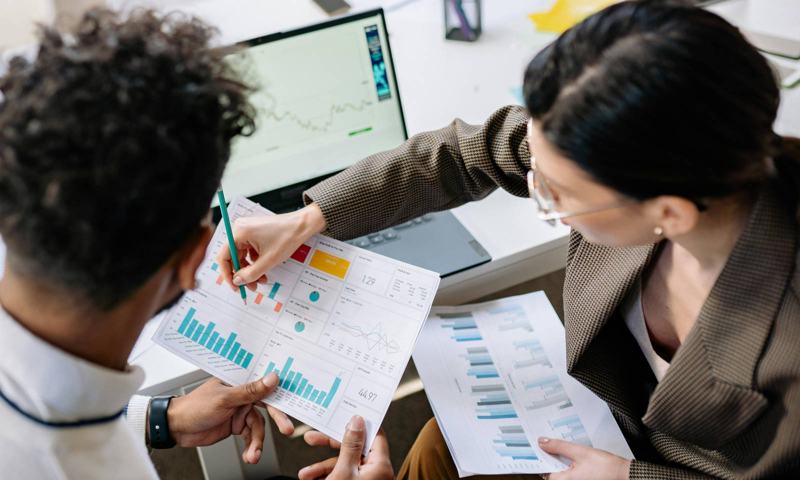 Two working professionals looking at graphs and charts