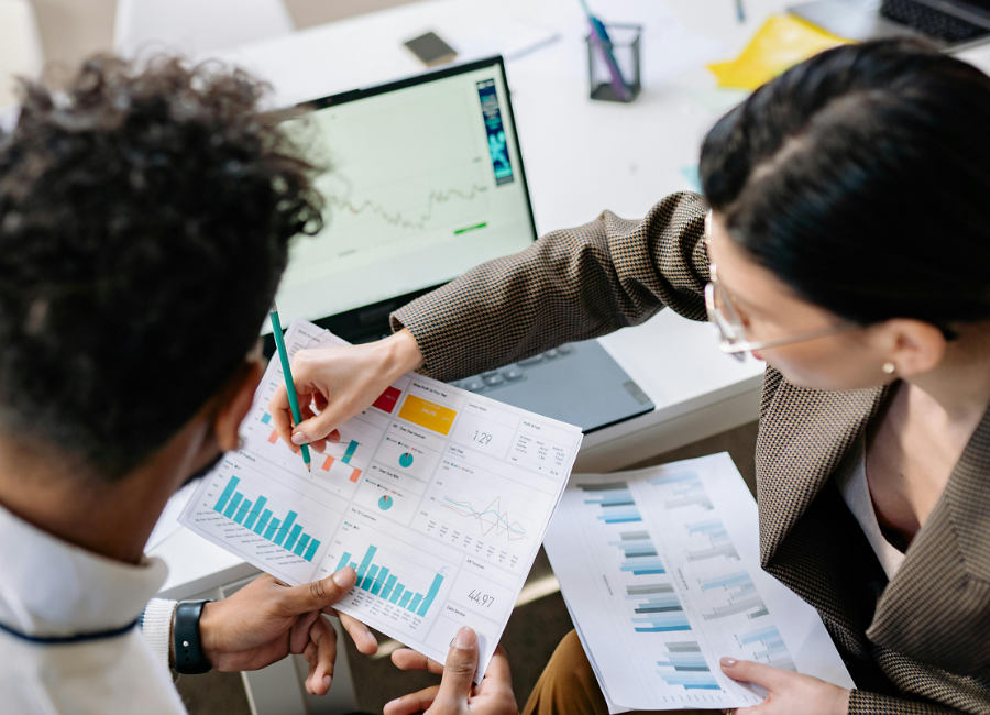 Two working professionals looking at graphs and charts