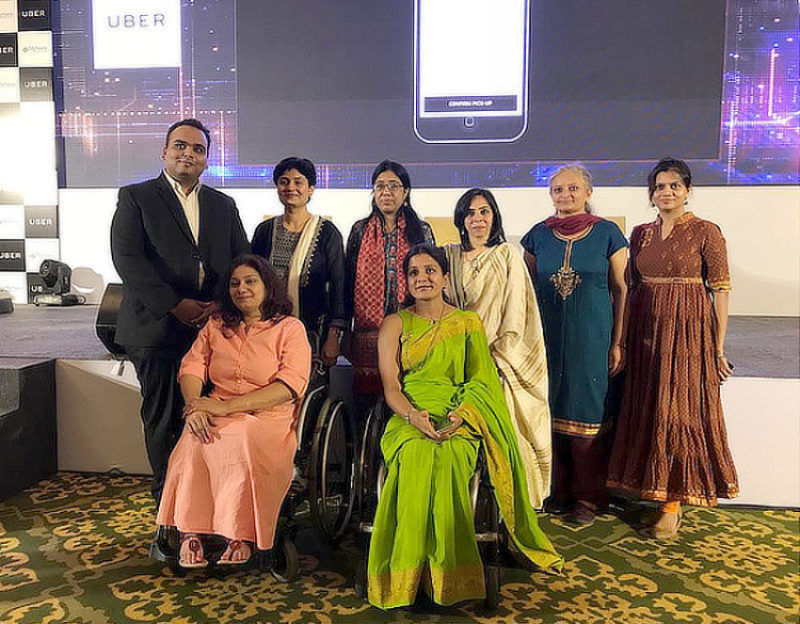 Team members, including two on wheelchair, in front of the workshop stage